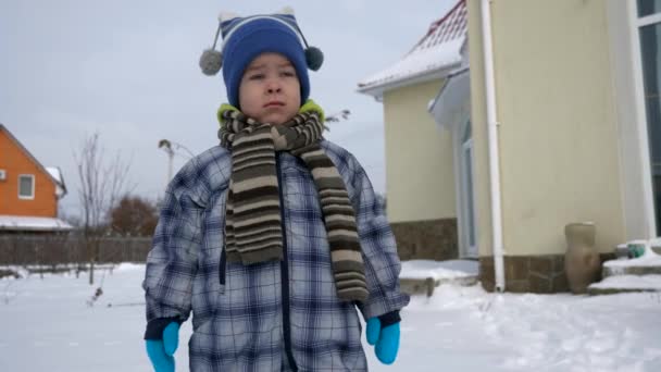 暖かい服でかわいい小さな子供屋外の裏庭に雪の上を歩きます 晴れた冬の日遅いモーション Fps を高速化します — ストック動画
