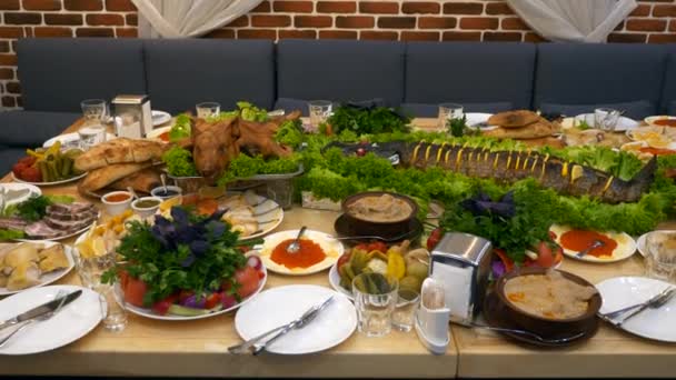 精美的服务和装饰假日宴会厅表与丰富的不同的食物沙拉炒全猪肉鱼 — 图库视频影像