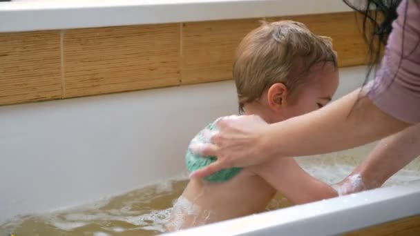 母亲在浴室里用海绵毛巾清洗孩子 快乐的孩子沐浴在浴缸里的浴缸里 慢动作0 速度60帧 — 图库视频影像