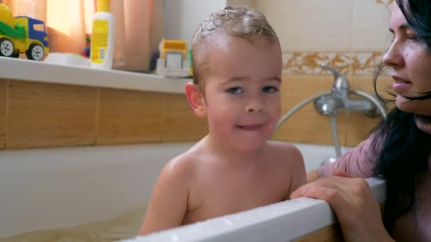 浴室のスポンジ タオルで彼女の子供を洗います 幸せなうれしそうな子をバスタブのお風呂で浴びる Fps スローモーション — ストック動画