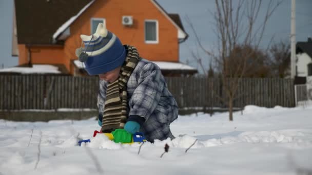 小男孩玩玩具卡车在雪在后院花园 冬季寒冷的天气 明亮的阳光明媚的一天 慢动作0 速度60帧 — 图库视频影像