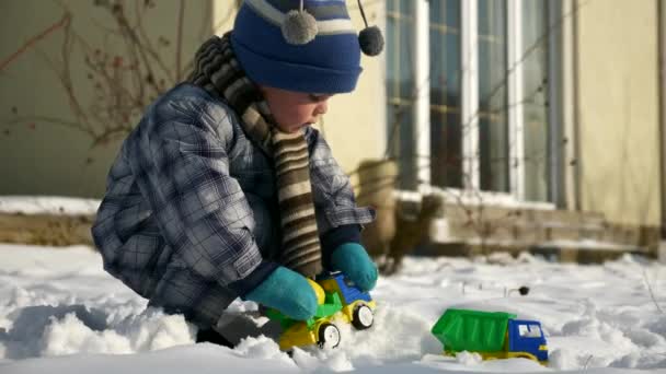 Little Boy Plays Toy Trucks Snow Backyard Garden Cold Weather — Stock Video