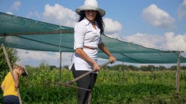 Çocuk arka bahçede çiftçiliğe yardım ediyor. 2x Yavaş çekim - 1 / 2 hız 60 fps