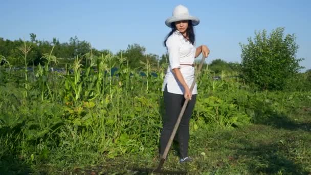 소녀가 마당의 정원에 벽돌로 잡초를 제거하다 — 비디오