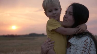 Sahada Sunset 'in önünde mutlu anne ve oğul. Sevgi ve Mutluluğun Olumlu Duygularını İfade Et