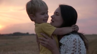 Sahada Sunset 'in önünde mutlu anne ve oğul. Sevgi ve Mutluluğun Olumlu Duygularını İfade Et