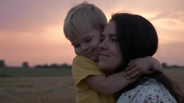 Sahada Sunset 'in önünde mutlu anne ve oğul. Sevgi ve Mutluluğun Olumlu Duygularını İfade Et
