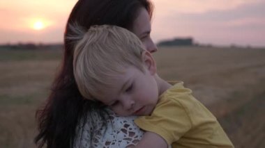 Sahada Sunset 'in önünde mutlu anne ve oğul. Sevgi ve Mutluluğun Olumlu Duygularını İfade Et