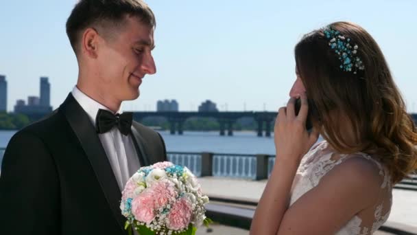 Bruidegom Wacht Terwijl Bruid Praten Smartphone Stadsgezicht Achtergrond Slow Motion — Stockvideo