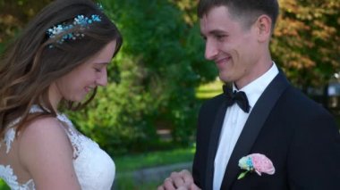 Gelin ve Damat Park 'ta yürüyüp birbirlerine bakıyorlar. Şehir Sahnesi. Yavaş çekim - 0.5 Hız 60 FPS 