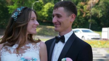 Gelin ve Damat Park 'ta yürüyüp birbirlerine bakıyorlar. Şehir Sahnesi. Yavaş çekim - 0.5 Hız 60 FPS 