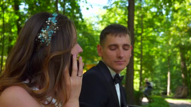 Menyasszony Smartphone Cseveg Amíg Vőlegény Vár Egy Pár Padon Parkban — Stock videók