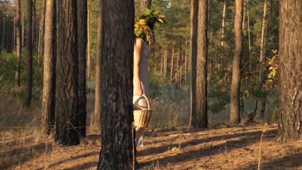 松の森の中でリースとバスケットウォークと白いドレスの女性 スローモーション60 Fps — ストック動画