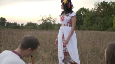 Kadın, Ormanın Ormanındaki Çimlerde Çalan Halk Müzisyenlerini Seviyor. 4K HDR