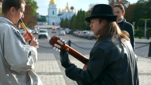 若い女性は街の広場で音楽を演奏ストリートミュージシャンを聞きます — ストック動画