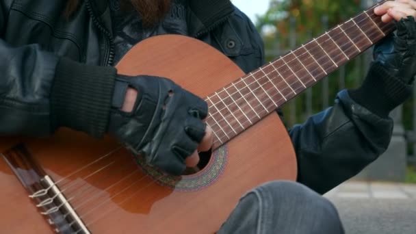 特写镜头街音乐家表演者在城市广场弹奏吉他 秋晨都市风貌 — 图库视频影像