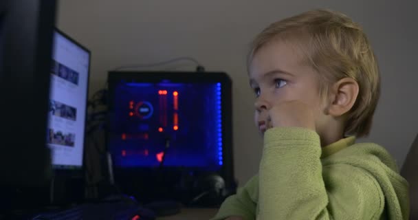 台式机显示器上严肃的小男孩观看录像 — 图库视频影像