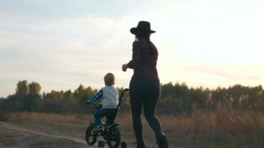 Anne, Oğula Kırsal Toprak Yolu 'nda ilk kez bisiklete binmeyi öğretiyor. Yavaş çekim