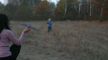 Anne ve Oğlu Açık Hava Oyuncak Uçağı Fırlatılıyor. Mutlu Çocuk Uçağı Yakaladı. Sonbahar Ormanı. 2x Yavaş çekim 60 FPS