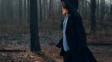 Kara Pelerinli Gezgin, Pelerinli Ormanda Yürüyor. Gezgin Keşiş Pilgrim. Sonbahar Sabahı. Gizemli Gezgin. 2x Yavaş çekim 60 fps 4K