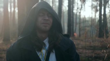 Keşiş duası. Kara Pelerinli Gezgin Pilgrim, Pelerin ve Pelerin ile Puslu Ormanda Dua Ediyor. Sonbahar Sabahı. 2x Yavaş çekim 60 fps 4K