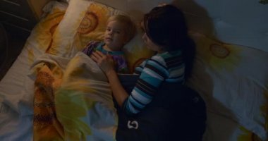 Anne, çocuğu yatağa yatırıp şarkı söyleyen ninniler anlatıyor. Noel arifesi gecesi. Yılbaşı Tatilleri