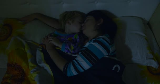 母と子供は夜のクリスマスイブの夜のベッドルームで寝る 年末年始 — ストック動画