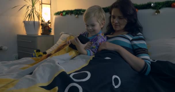 Mor Och Barn Tittar Home Video Smartphone Medan Ligger Sängen — Stockvideo