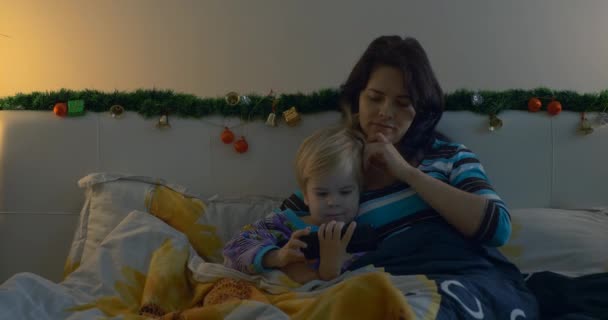 Mor Och Barn Tittar Home Video Smartphone Medan Ligger Sängen — Stockvideo