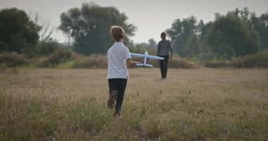 Man and Boy, Oyuncak Uçakla Sahada Oynuyor. Baba ve Çocuk Doğa 4K 10-bit 'te Birlikte Zaman Geçiriyorlar