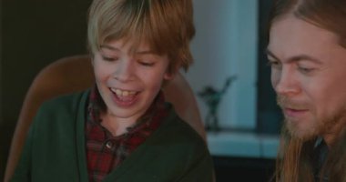 Amcası ve babası olan bir çocuk heyecanlı bir kitap okuyor. 4K 10-bit eğleniyor.