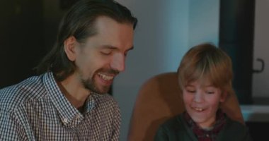 Amcası ve babası olan bir çocuk heyecanlı bir kitap okuyor. 4K 10-bit eğleniyor.