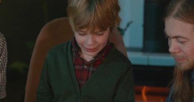 Amcası ve babası olan bir çocuk heyecanlı bir kitap okuyor. 4K 10-bit eğleniyor.