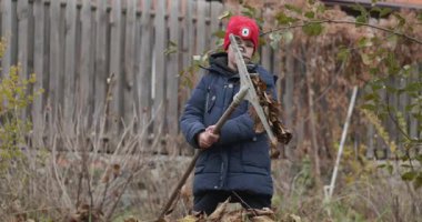 Boy Rakes Arka Bahçede Yapraklar. Soğuk Sonbahar Havası Ağır çekim 4K 10-bit 