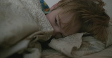 Uyuyan şirin küçük çocuk. Çocuk, Yatak Odasında Sabah Yatağında Uyuyor. 4K 10-bit