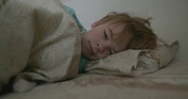 Uyuyan şirin küçük çocuk. Çocuk, Yatak Odasında Sabah Yatağında Uyuyor. 4K 10-bit