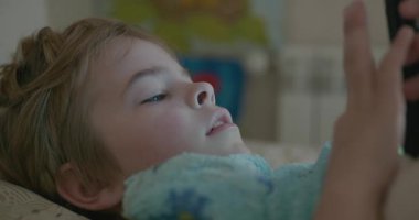 Kid Boy Use Smartphone After Sleep in Bed. Morning Rest. 4K 10-bit