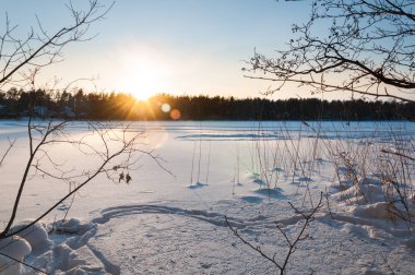 Güzel kış sahne. Donmuş göl günbatımı karla kaplı.