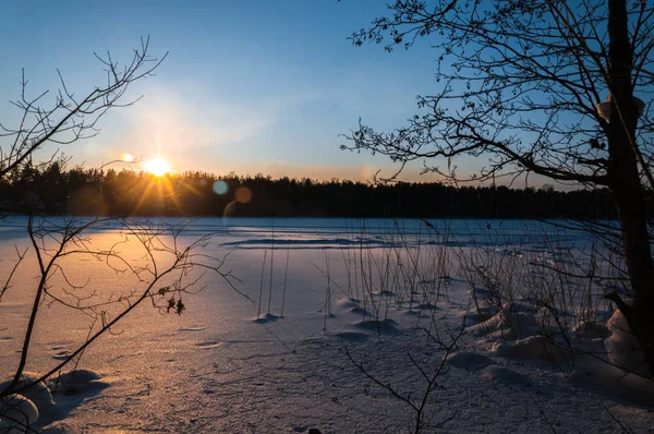 Прекрасная зимняя сцена. Закат на замёрзшем озере, покрытом снегом . — стоковое фото