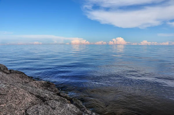 Taşlı Barajı quay Ladoga Gölü. Güneşli yaz manzara. Mavi gökyüzü ve bulutlar yansıtan su yüzey