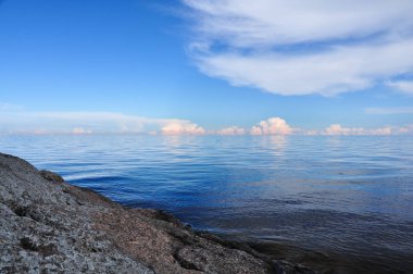 Taşlı Barajı quay Ladoga Gölü. Güneşli yaz manzara. Mavi gökyüzü ve bulutlar yansıtan su yüzey