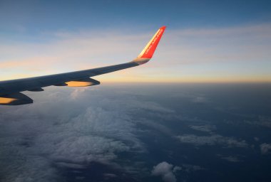 Bulutların üzerinde güneş doğarken uçan uçak. Hava penceresi görünümü.