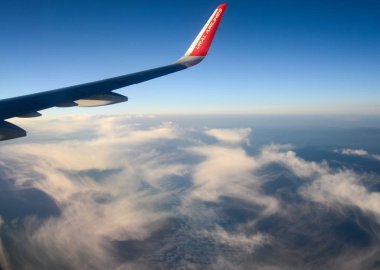 Bulutların üzerinde güneş doğarken uçan uçak. Hava penceresi görünümü.