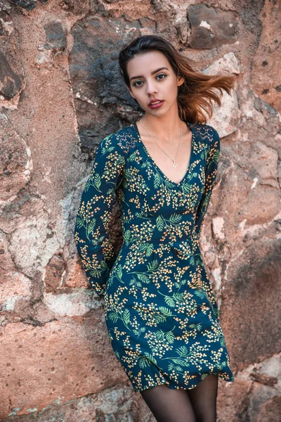 Güzel, sıska Arnavut kız poz veriyor ve turuncu mavi süs elbisesini gösteriyor