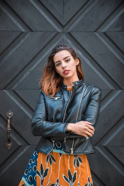 Güzel, sıska Arnavut kız poz veriyor ve turuncu mavi süs elbisesini gösteriyor
