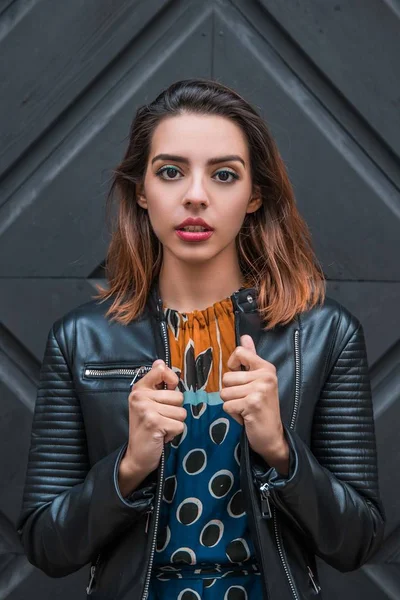 Güzel, sıska Arnavut kız poz veriyor ve turuncu mavi süs elbisesini gösteriyor