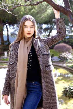 Baharda bahçede poz veren uzun saçlı genç kız.