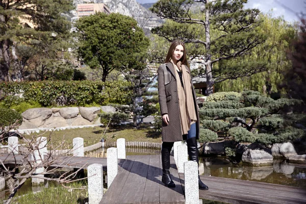 Baharda bahçede poz veren uzun saçlı genç kız.