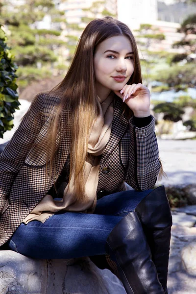 Baharda bahçede poz veren uzun saçlı genç kız.