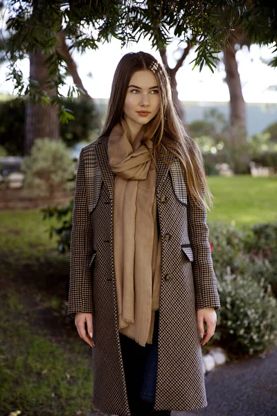 Baharda bahçede poz veren uzun saçlı genç kız.